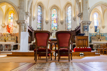 Interior of a church with two chairs in the center of the photo