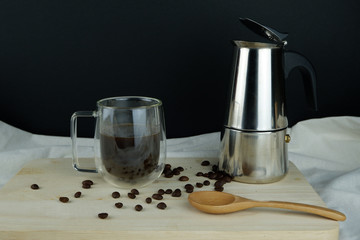 Americano coffee beside moka pot and black bean