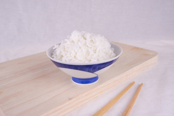 White rice on ceramic plate top view with bamboo chopstick