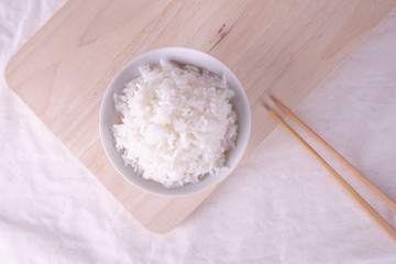 White rice on ceramic plate top view with bamboo chopstick