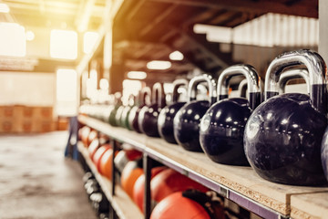 Kettlebells with various colors. Sport equipment in gym. kettlebell on floor background, Fitness training. Shot of a bunch of kettle bells lined up in a row on the floor of a gym