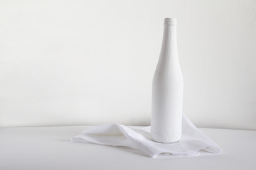 White bottle on a towel on a light background.