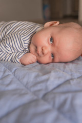 Baby boy lying on front in living room 