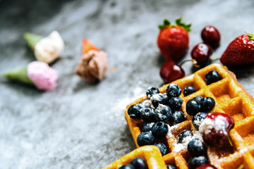 Background of foods refreshing ice cream in cones with red fruits and waffles, with negative space for summer design.