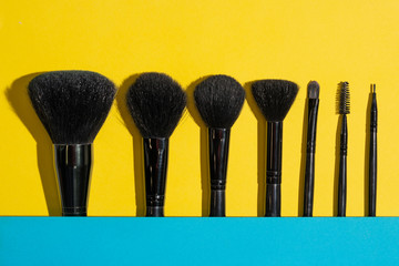 Make up brushes set on yellow background.