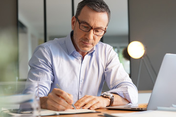 Business manager working in office on laptop