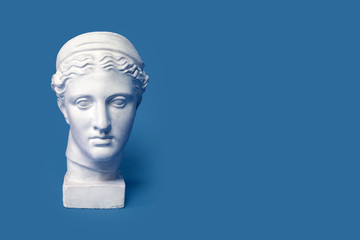 Marble head of young woman, ancient Greek goddess bust isolated on pink background. Gypsum copy of a statue Diana head