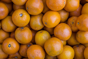 Texture, many oranges lie on the counter of a grocery store. Fresh fruits