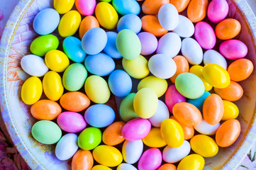 Bright colored eggs, large and small for Easter Sunday. Traditional treats. Copy space. Background of colored eggs