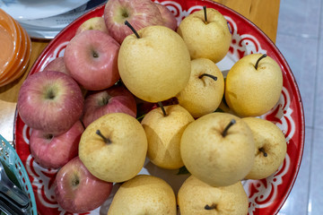 Red apples and honey barrow placed on a tray.
