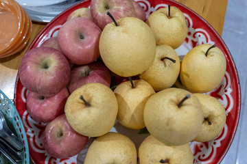 Red apples and honey barrow placed on a tray.
