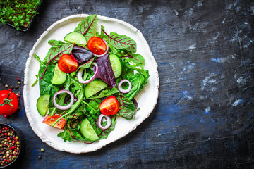 Healthy salad, leaves mix salad (mix micro greens, cucumber, tomato, onion, other ingredients). keto or paleo diet top concept, food background copy space for text