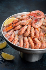 A lot of shrimp with lemon in an iron dish