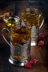 Tea in a glass mug inserted in an iron cup holder