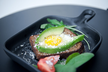 Avocado sandwich with fried egg. Egg on toasted bread for healthy breakfast or snack, copy space. Vegan avocado sandwiche top view close-up