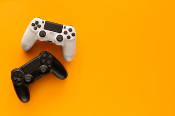 Stock photo of two gamepads on a yellow background and copy space