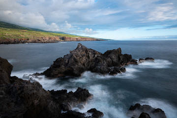 coucher de soleil sur la côte de l'océan indien, vagues déferlant sur les rochers