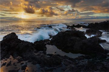 coucher de soleil sur la côte de l'océan indien, vagues déferlant sur les rochers