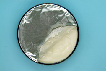 a jar of open cream on a blue background