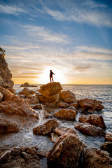Girl in backlight on a rock on the Costa Brava in Catalonia