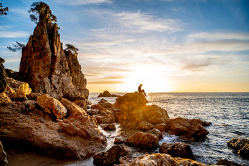 Girl in backlight on a rock on the Costa Brava in Catalonia
