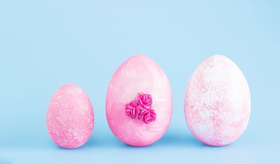 Easter eggs collection. Chicken eggs are painted pink isolated on a blue background. Creative card with Easter. Banner. Copy space