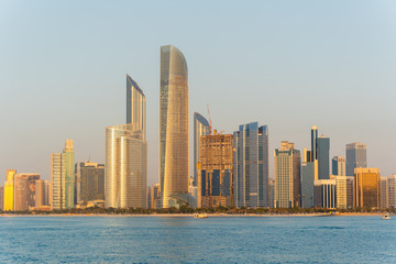 Naklejka premium Golden hour view of Abu Dhabi financial district skyline. Luxury lifestyle hotels and business of United Arab Emirates. 
