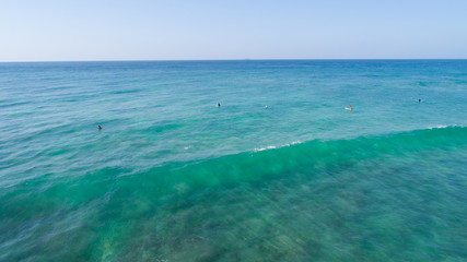 Aerial view from drone of surfers surfing in the indian ocean