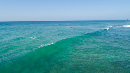 Fototapeta na wymiar Aerial view from drone of surfers surfing in the indian ocean