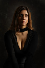 Fototapeta premium Portrait of a young adorable brunette woman in a black dress