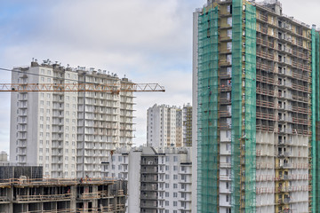 A lot of builders in helmets and masks on the top floor of a house under construction