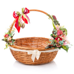 Fototapeta na wymiar Round wicker easter basket with beautiful ribbon bow. Decor with flowers, quail eggs and ribbons on white background.