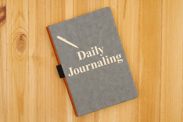 Daily journaling message written on a journal on a desk