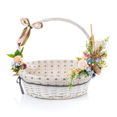 Fototapeta na wymiar Wicker basket decorated with different flowers in delicate colorsisolated on a white background