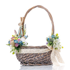 Wicker basket with floral decor and ribbons on white background