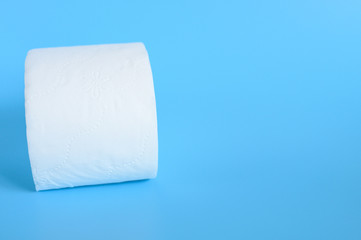 rolled white toilet paper in a blue background. space for text
