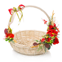 Fototapeta na wymiar Easter basket made of natural vines with handmade decor in red. Basket with floral decoration on white background