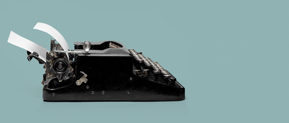 Black old typewriter with white paper sheet