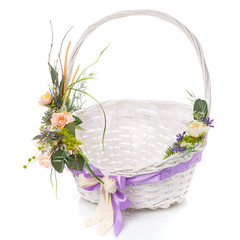 Fototapeta na wymiar Decor with green leaves, delicate pink flowers and wooden branches on a white Easter basket. on white background