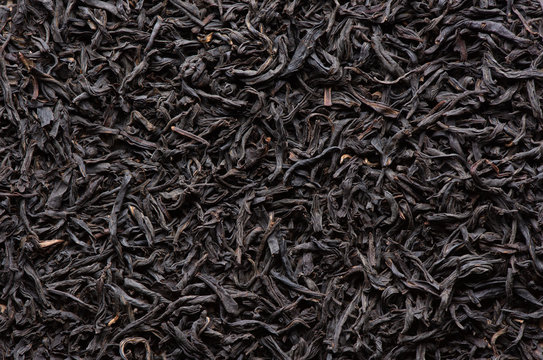 Dry black tea leaves background