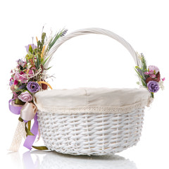 Fototapeta na wymiar White wicker basket with flower decor and fabric inside on a white background