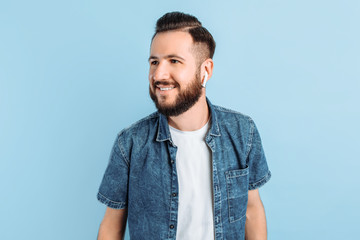 A man in wireless headphones on a blue background