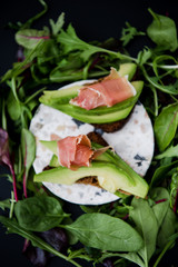 Avocado sandwich with jamon. Toasted bread for healthy breakfast or snack, copy space. Spanish tapas. Italian brushetta. Vegan avocado sandwich top view close-up