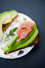 Avocado sandwich with jamon. Toasted bread for healthy breakfast or snack, copy space. Spanish tapas. Italian brushetta. Vegan avocado sandwich top view close-up
