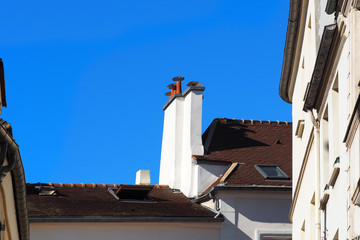 Mediterranean old white houses with tiled roofs and chimneys on a sunny summer day, blue sky