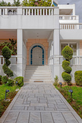 luxury house entrance path and stairs to white door, Athens Greece