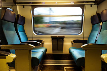 Moving train four empty coach seat blue upholstery swiss sbb rail network