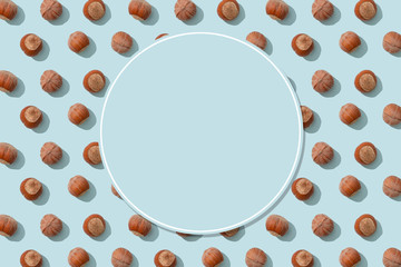 Hazelnut pattern on blue background with copy space. Nuts, raw ingredient. Wrapping paper,...