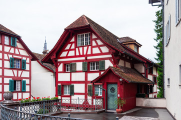 Fototapeta premium Colorful old wooden building in Lucerne Switzerland with exposed red wood overcast day