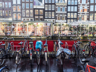 Aparcamiento de bicis frente al mercado de tulipanes de Amsterdam con las casas típicas al fondo
